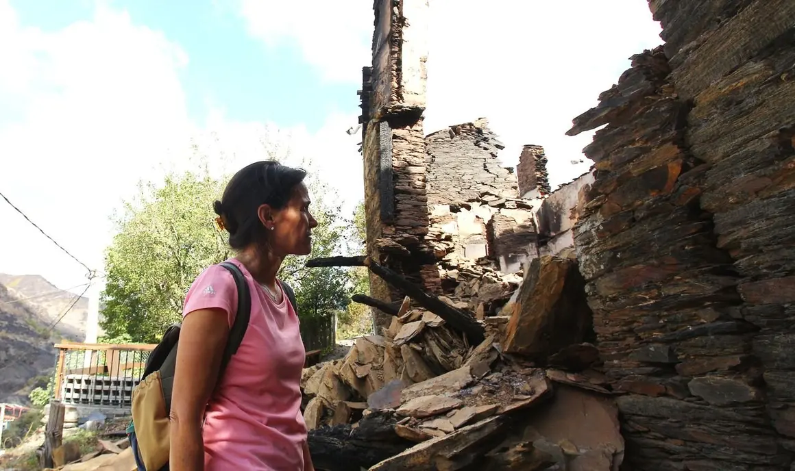 Silvia Vergara, vecina de Lusio (León), junto a su casa arrasada por el fuego
