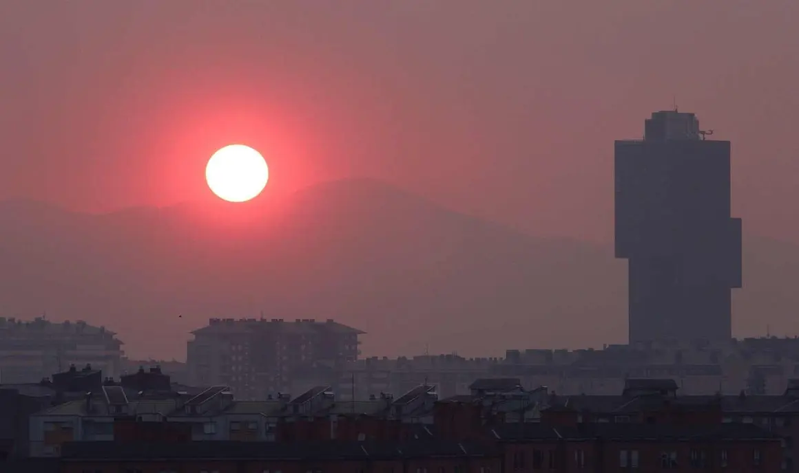 El sol enrojecido por el humo de los incendios se oculta en el atardecer del Bierzo