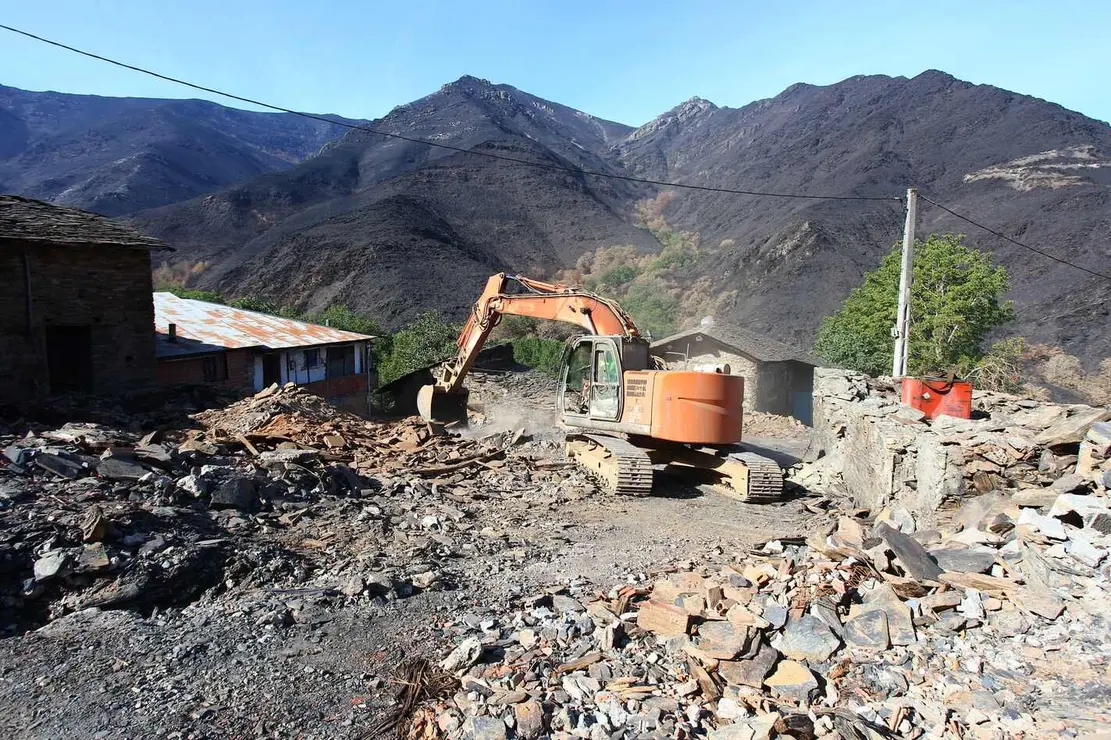 Trabajos de derribo y desescombro de las casas afectadas por el incendio en la localidad de Lusio.