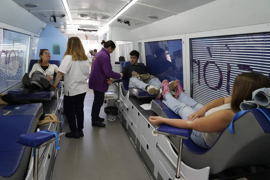 El secretario general en Hermandad de Donantes de Sangre del Bierzo y Laciana, José Miguel Álvarez (D), junto al donante varón con más donaciones del Área de Salud El Bierzo, Isaac Álvarez (I), junto al equipo móvil de donación