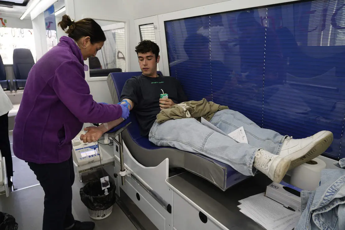 El secretario general en Hermandad de Donantes de Sangre del Bierzo y Laciana, José Miguel Álvarez (D), junto al donante varón con más donaciones del Área de Salud El Bierzo, Isaac Álvarez (I), junto al equipo móvil de donación