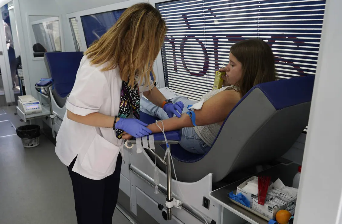 El secretario general en Hermandad de Donantes de Sangre del Bierzo y Laciana, José Miguel Álvarez (D), junto al donante varón con más donaciones del Área de Salud El Bierzo, Isaac Álvarez (I), junto al equipo móvil de donación