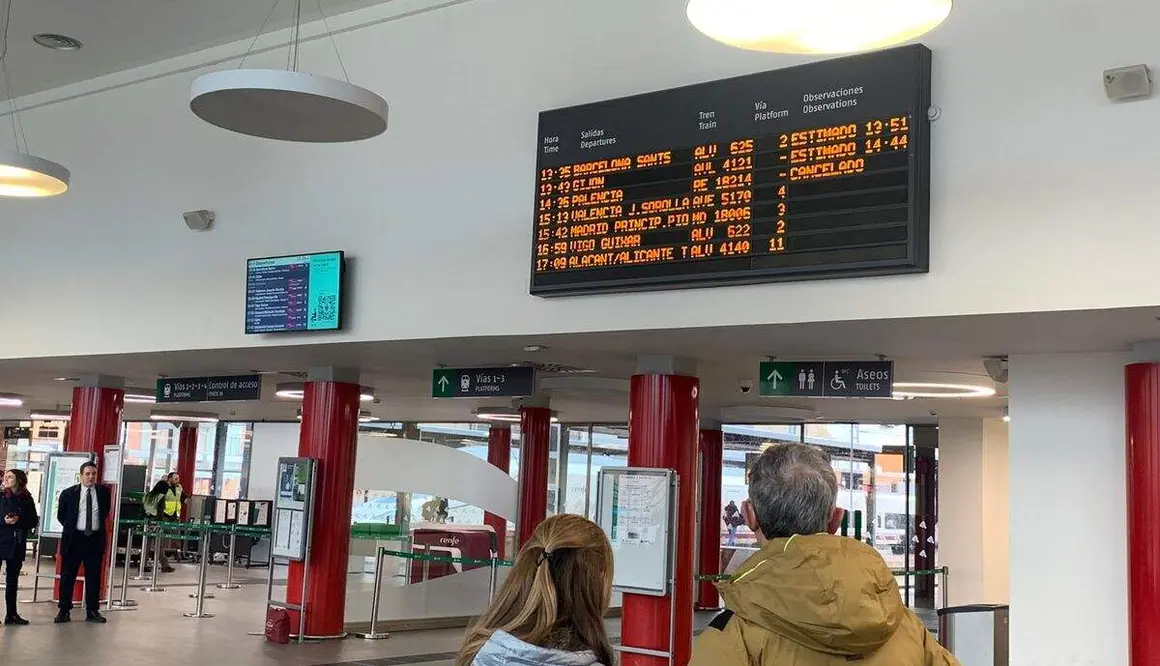 Usuarios del tren observan la pantalla con retrasos y cancelaciones de la Estaci&oacute;n de Le&oacute;n. Foto: A. Laliena
