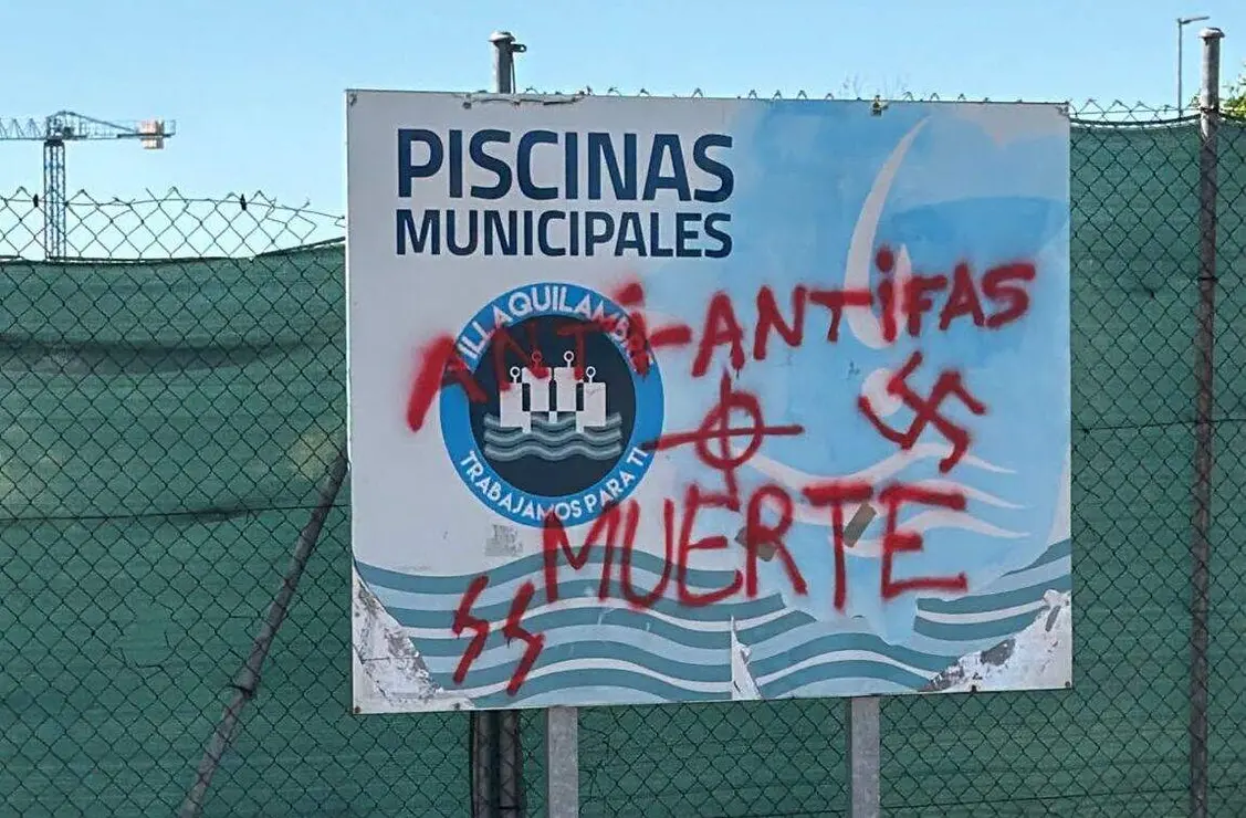 El cartel de las piscinas municipales ha sido vandalizado con un esv&aacute;stica y simbolog&iacute;a fascista, mientras un banco ha sido destrozado y se han causado da&ntilde;os materiales en un parque infantil. Foto: Ayto. Villaquilambre.