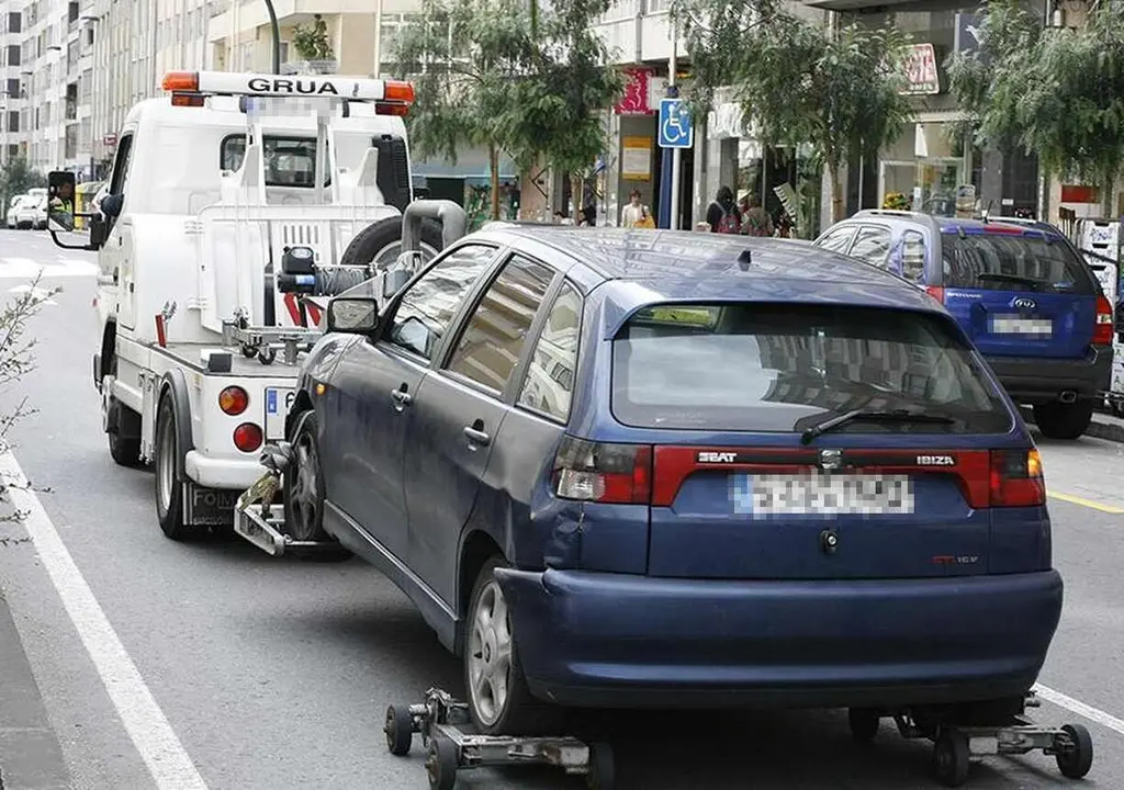 Imagen de una grúa retirando un vehículo al depósito municipal.