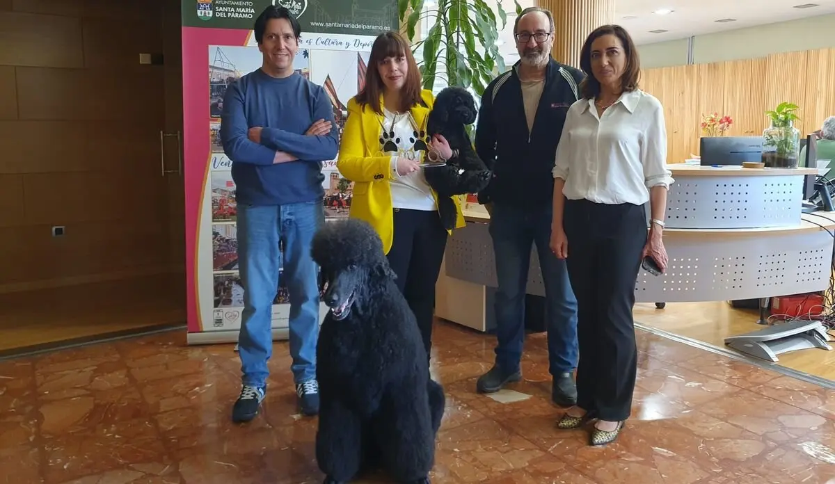 Verónica de Paz, ganadora del oro de peluquería canina, y sus dos caniches, junto a miembros del Ayuntamiento de Santa María del Páramo.