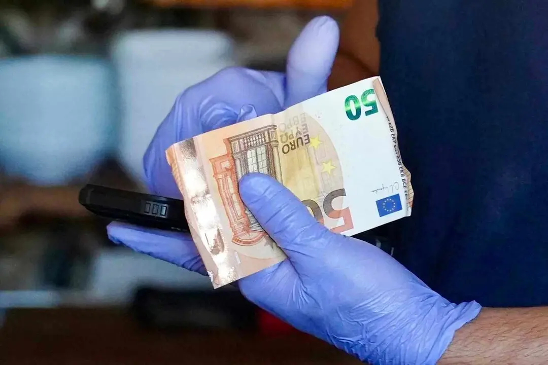 Un camarero recoge dinero en efectivo ante la imposibilidad de cobrar con tarjeta durante el apagón.