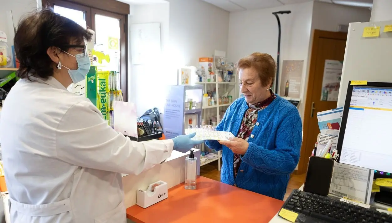 Una usuaria recoge la medicación semanal en la farmacia rural de Valdeavellano de Tera (Soria).