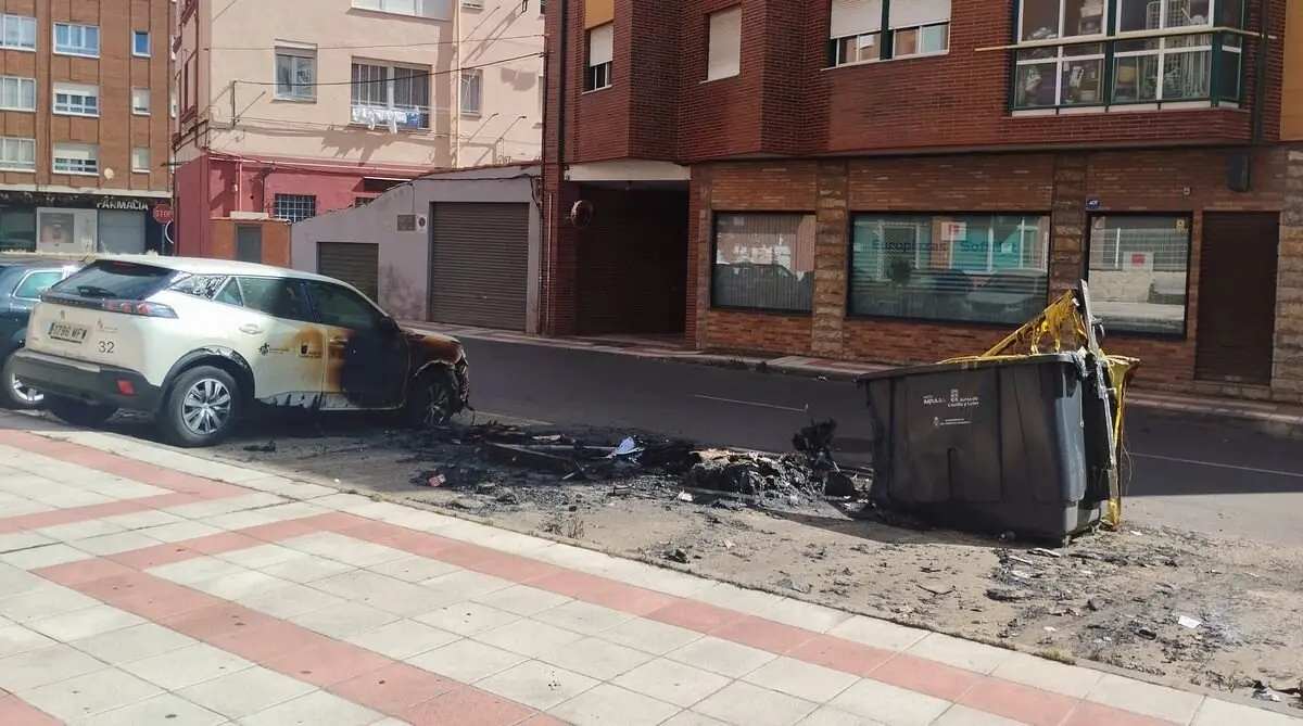 Los contenedores calcinados y el coche visiblemente afectado pro las llamas. Foto: Ayuntamiento de San Andrés del Rabanedo.