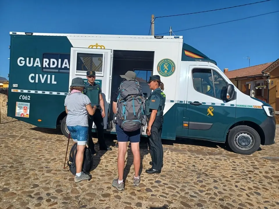 Una patrulla de la Guardia Civil de León presta asistencia a unos peregrinos en el Camino de Santiago.
