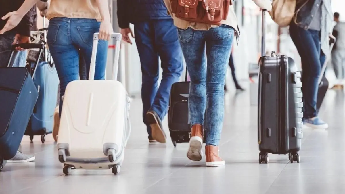 Viajeros con maletas en una estación.