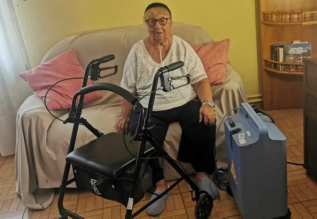 María Dolores Bayo vive conectada a un equipo de oxígeno y necesita de un andador para moverse. Ha preferido encerrarse en su casa del pueblo en lugar de evacuar La Baña (León) por los incendios.