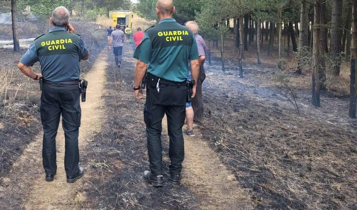 Efectivos de la Guardia Civil, junto al investigado, en el lugar del incendio.