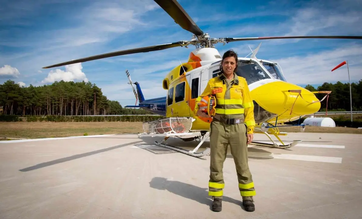 Sara, bombero forestal, junto al helicóptero en el que se desplaza.