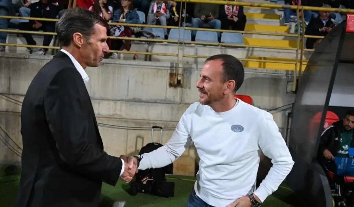 Los entrenadores se saludan momentos antes del inicio del partido.