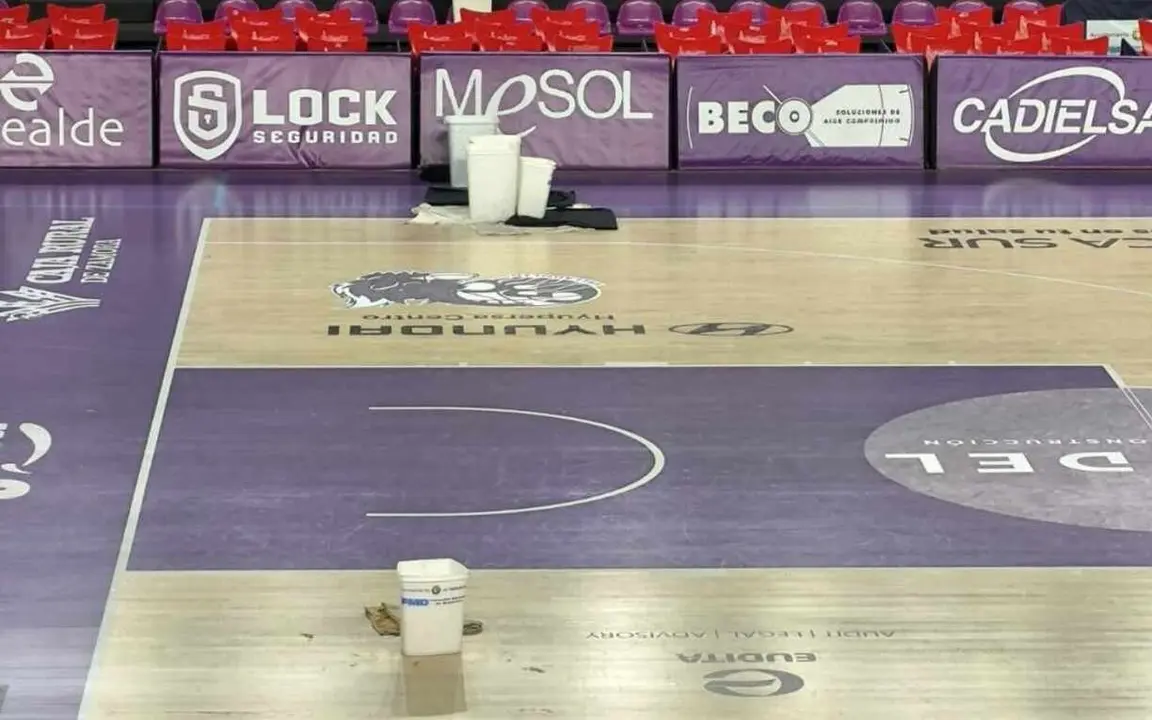 Imagen de los cubos para recoger el agua de las goteras que impidieron la celebración del partido.