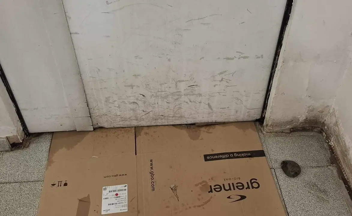 Cartones para evitar que el agua se cuele en el interior del recinto sanitario, en el prolifera el moho y la humedad.