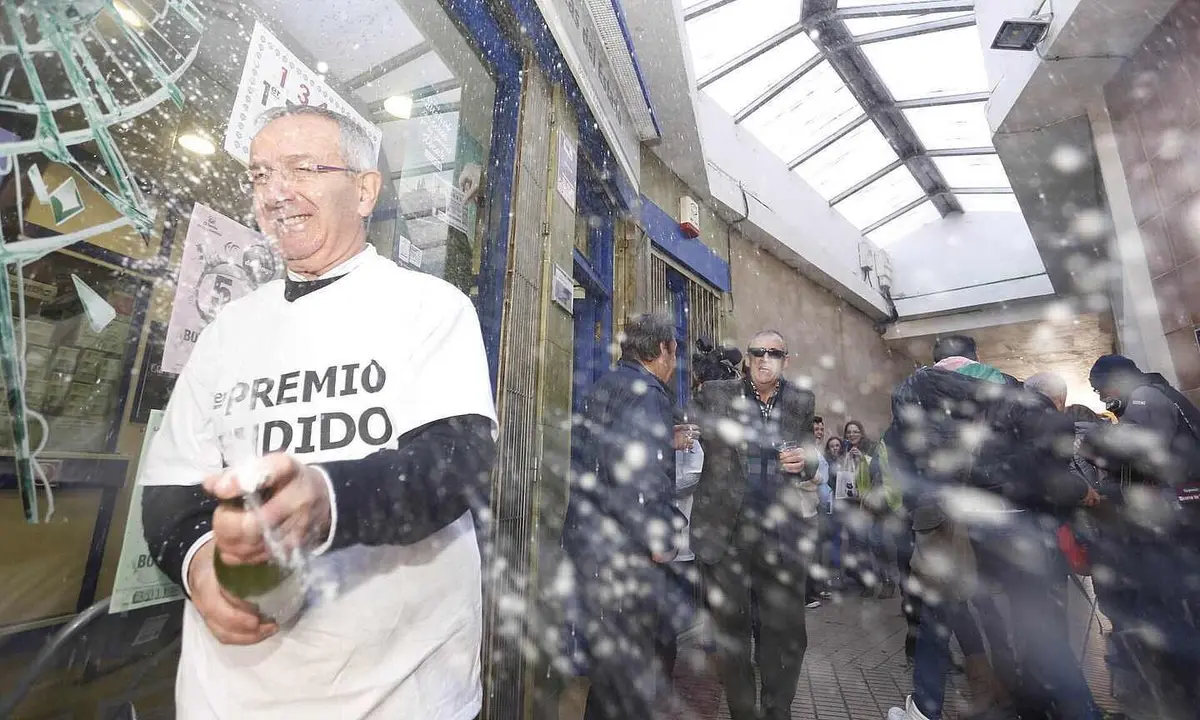 El due&ntilde;o de la administraci&oacute;n de la localidad leonesa de Bo&ntilde;ar, ubicada en la calle Concordia, celebra en 2014 la venta de cuatro millones del Gordo, el 13437. Foto: Campillo