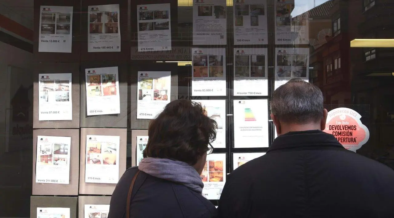 Una pareja mira los anuncios de una inmobiliaria en Valladolid