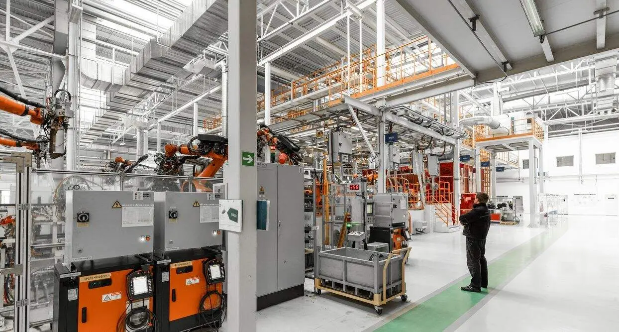 Photo of automobile production line. Welding car body. Modern car assembly plant. Auto industry. Interior of a high-tech factory, modern production.
