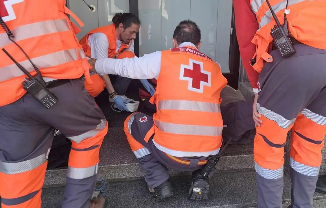 Efectivos de Cruz Roja durante la atenci&oacute;n a uno de los asistentes al acto procesional.