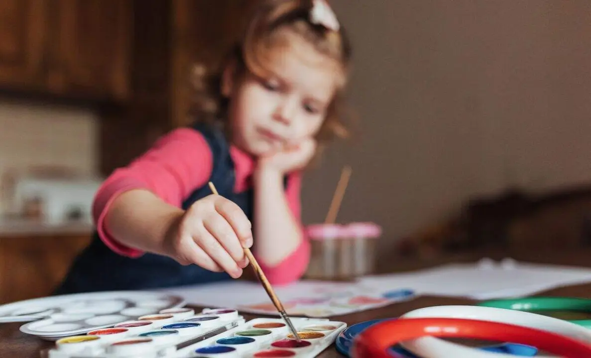 Cute happy little girl, adorable preschooler, painting with water color on canvas. Baby close up.