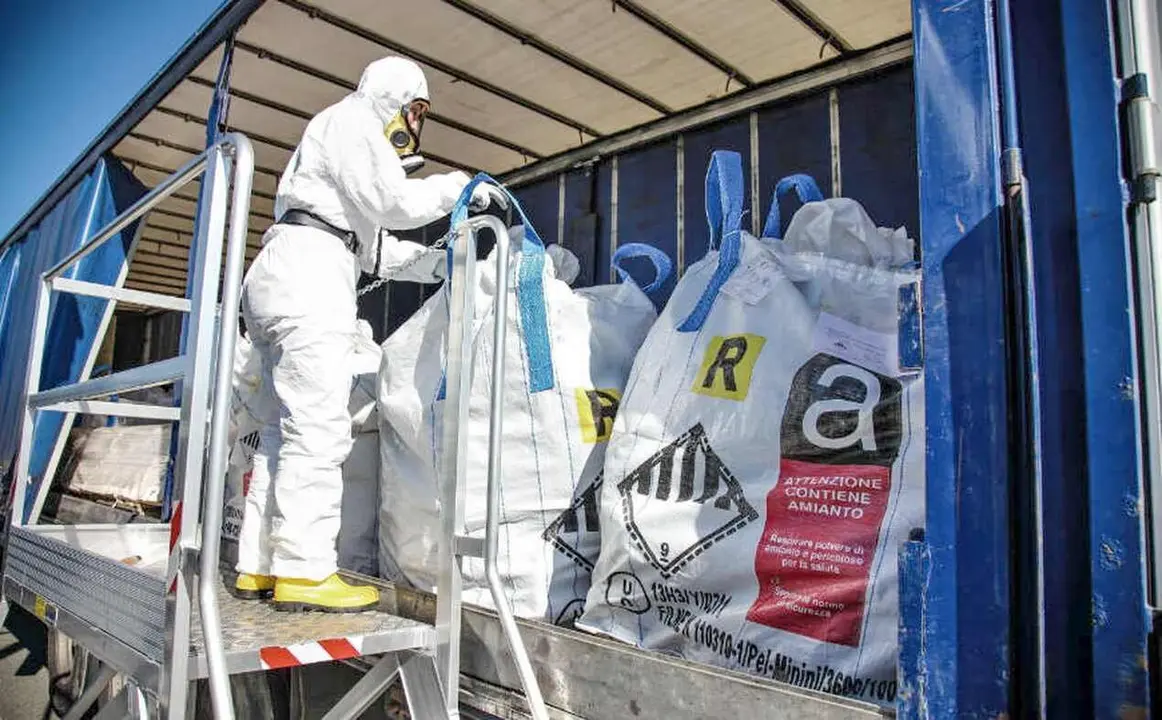 Obreros, con equipos especializados, proceden al movimiento de residuos con amianto.