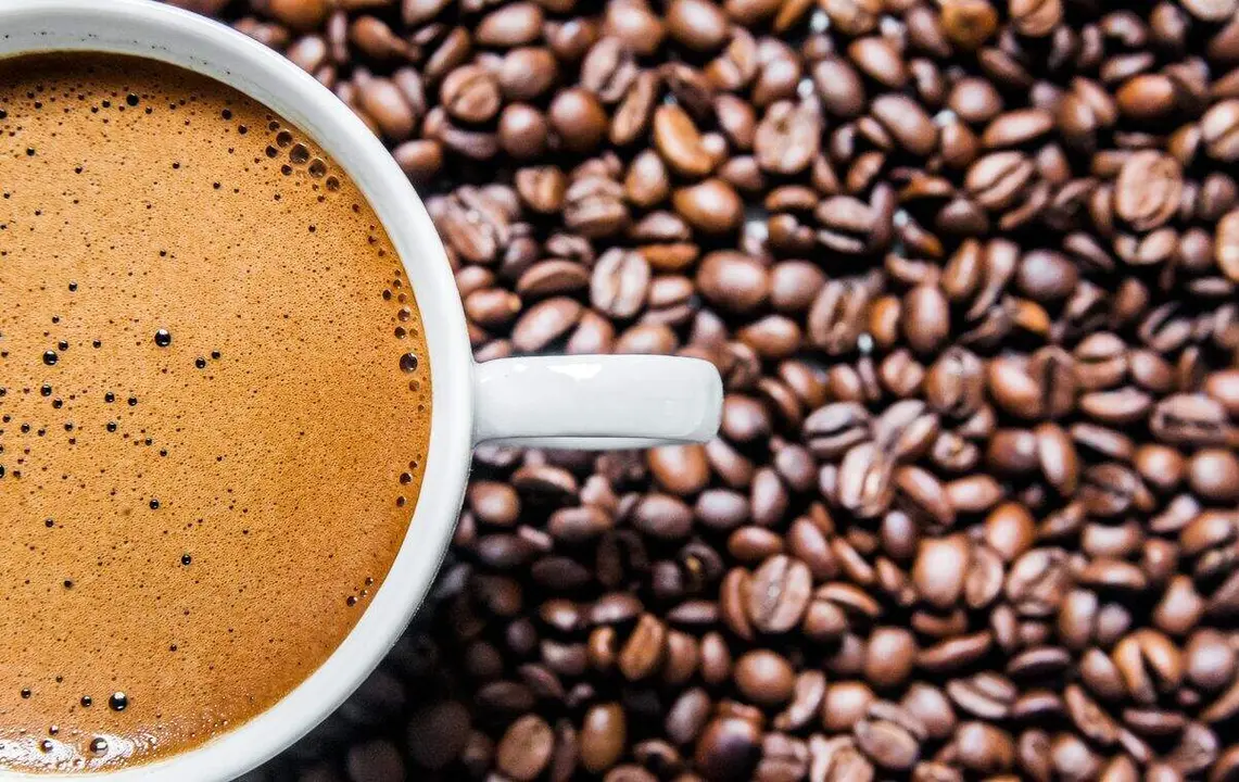 Coffee cup and coffee beans on table, top view, love coffee, Brown coffee beans isolated on white background, Hot Coffee cup with Coffee beans