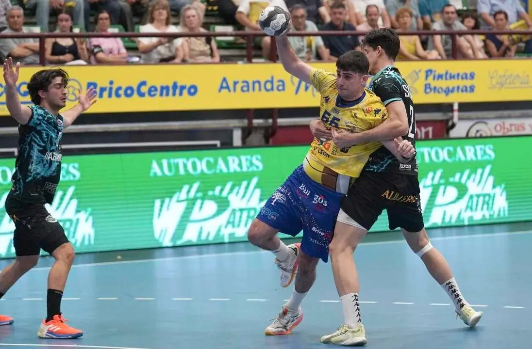 La defensa del Ademar intenta frenar el ataque del equipo local.
