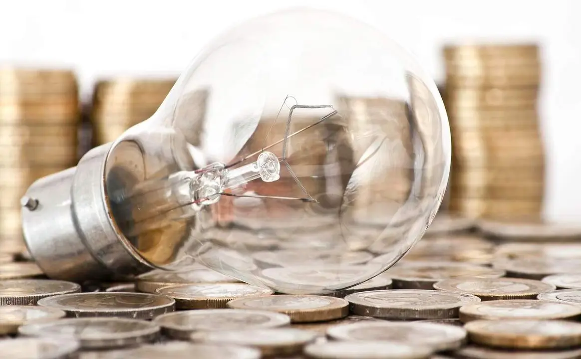 filament bulb lying on euro coins