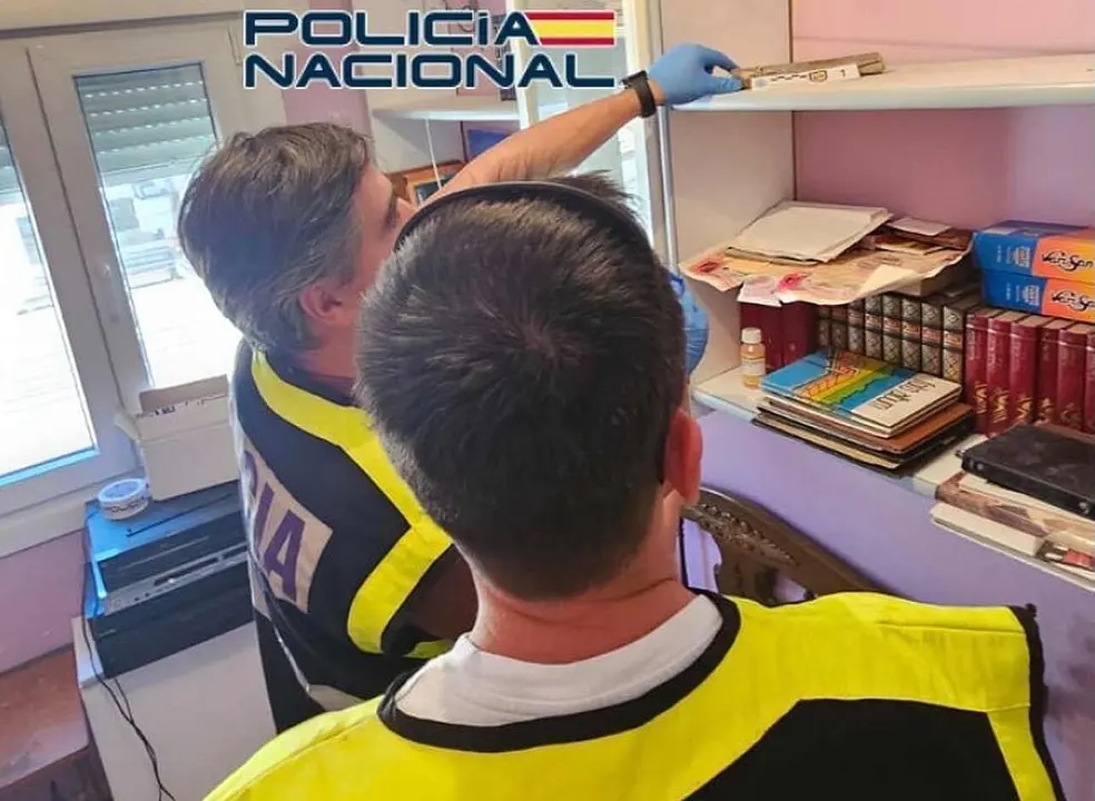 Efectivos de la Polic&iacute;a Nacional junto al cartucho de dinamita localizado en la vivienda.