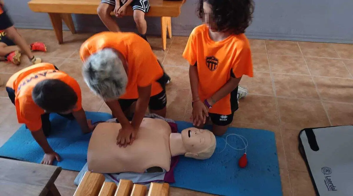 Los participantes del campamento realizando las pr&aacute;cticas del taller de RCP del Centro de Salud de Toreno