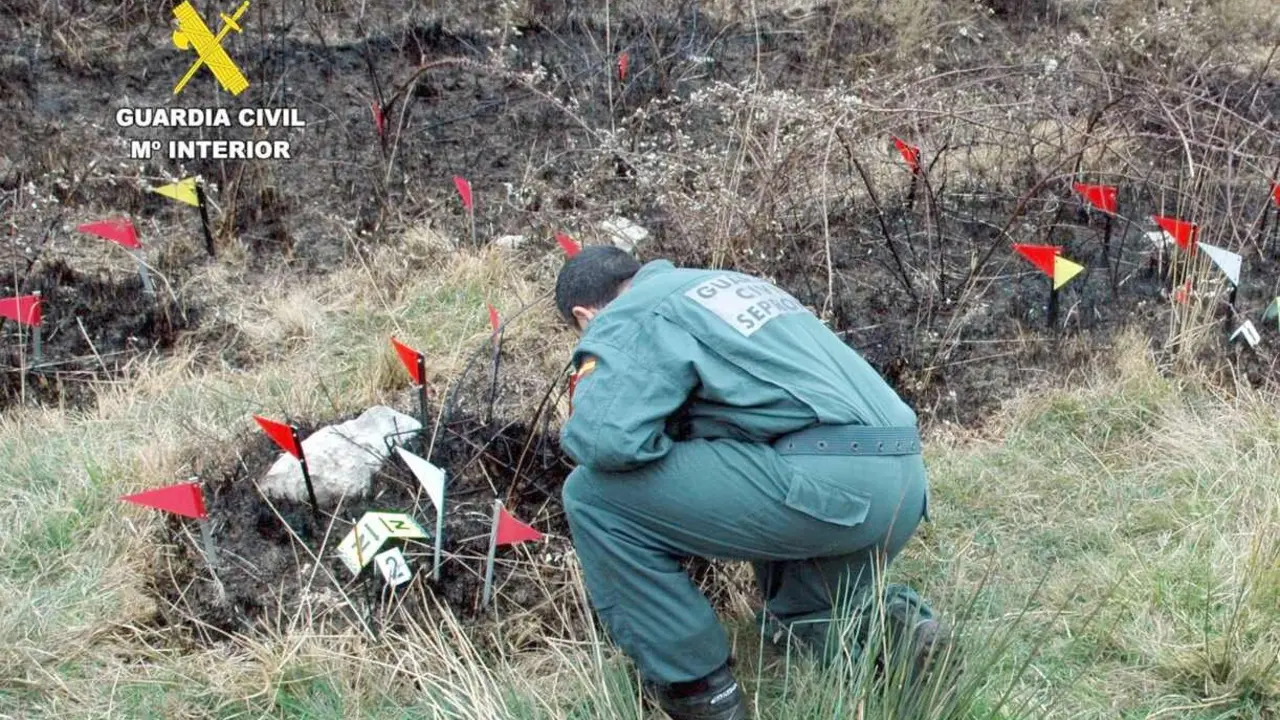 Un guardia civil, durante la investigación de un incendio.
