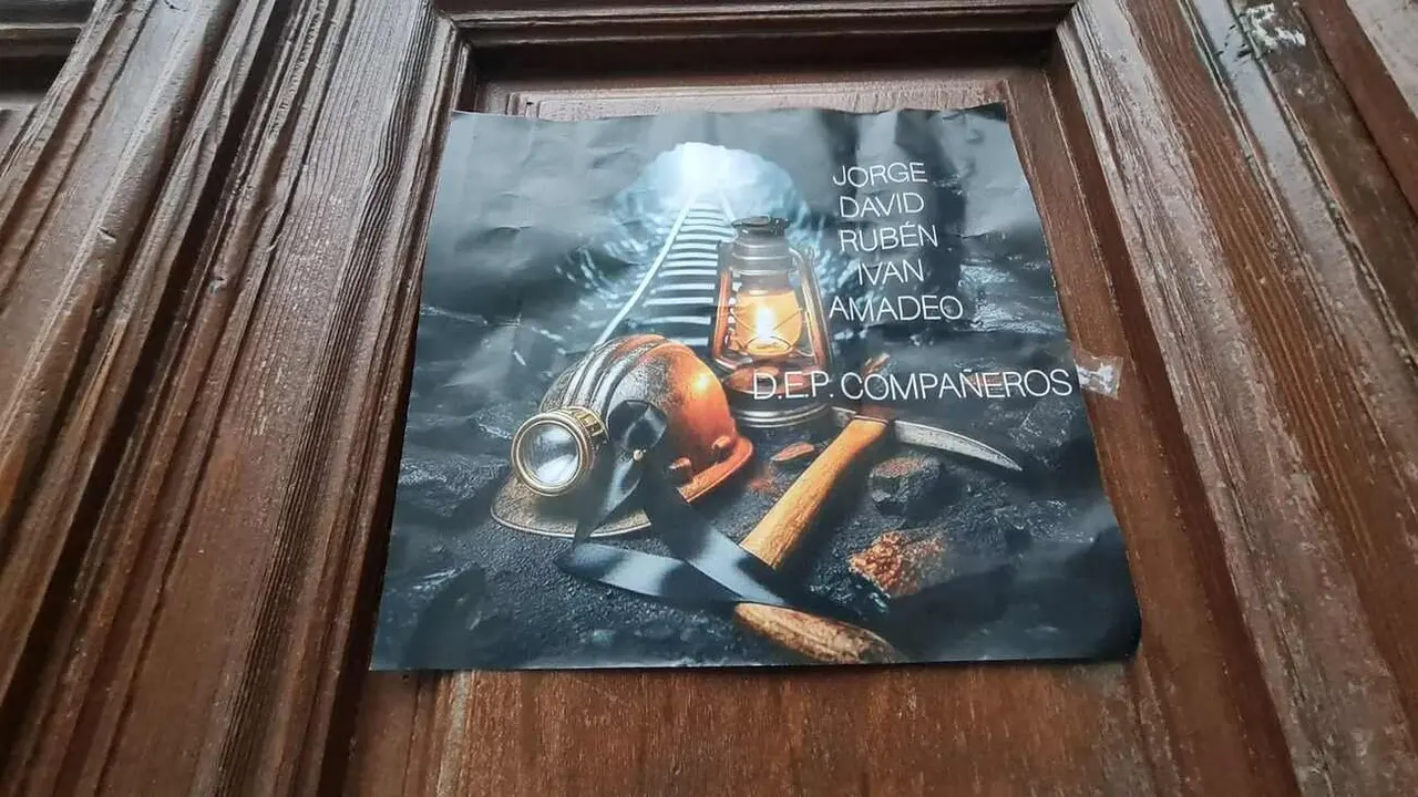 Un cartel con los nombres de los mineros fallecidos en la puerta de las oficinas de la empresa titular de Cerredo.
