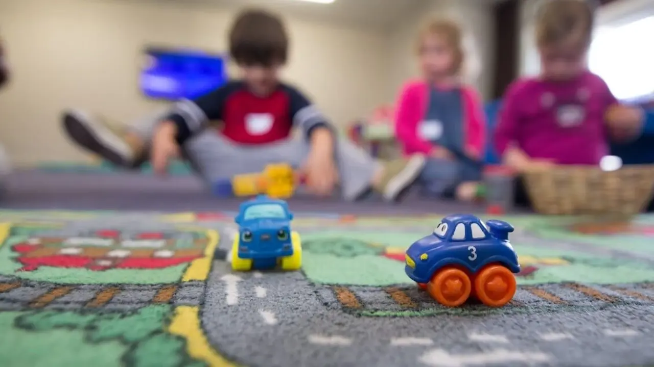 Varios niños y niñas juegan en una guardería.