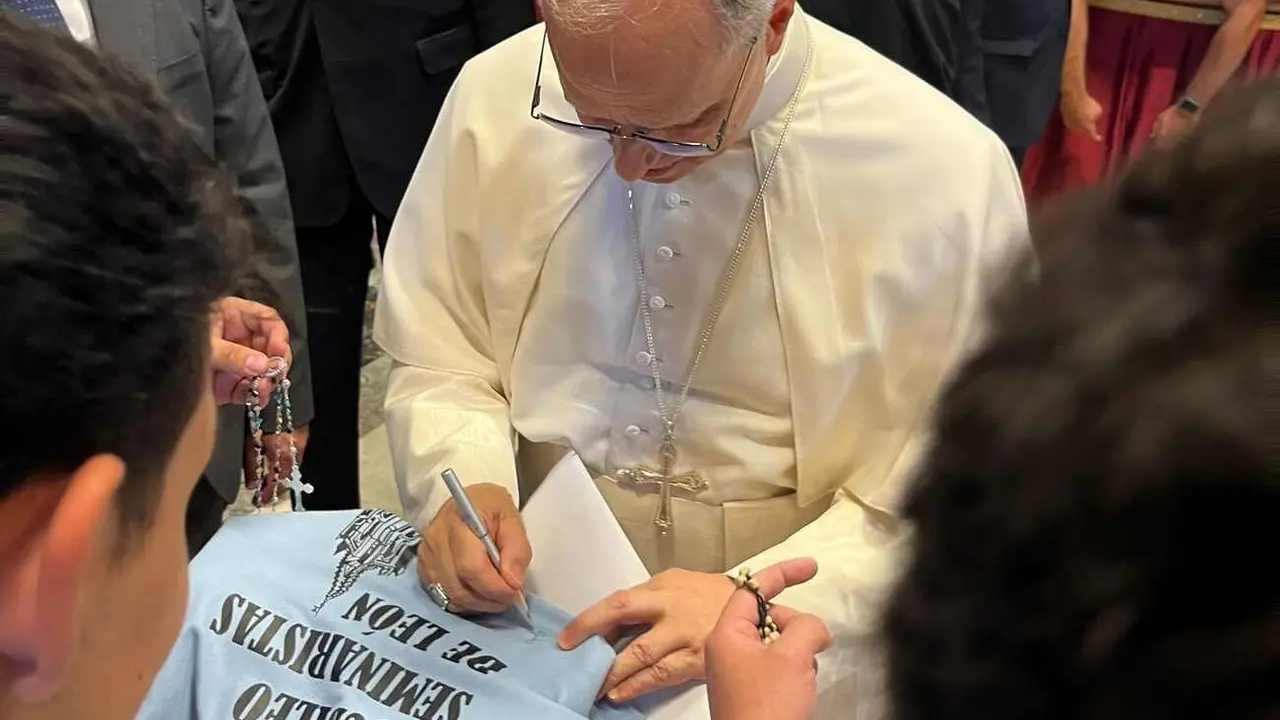 Momento en el que el Papa León firma sobre la camiseta alusiva a León.
