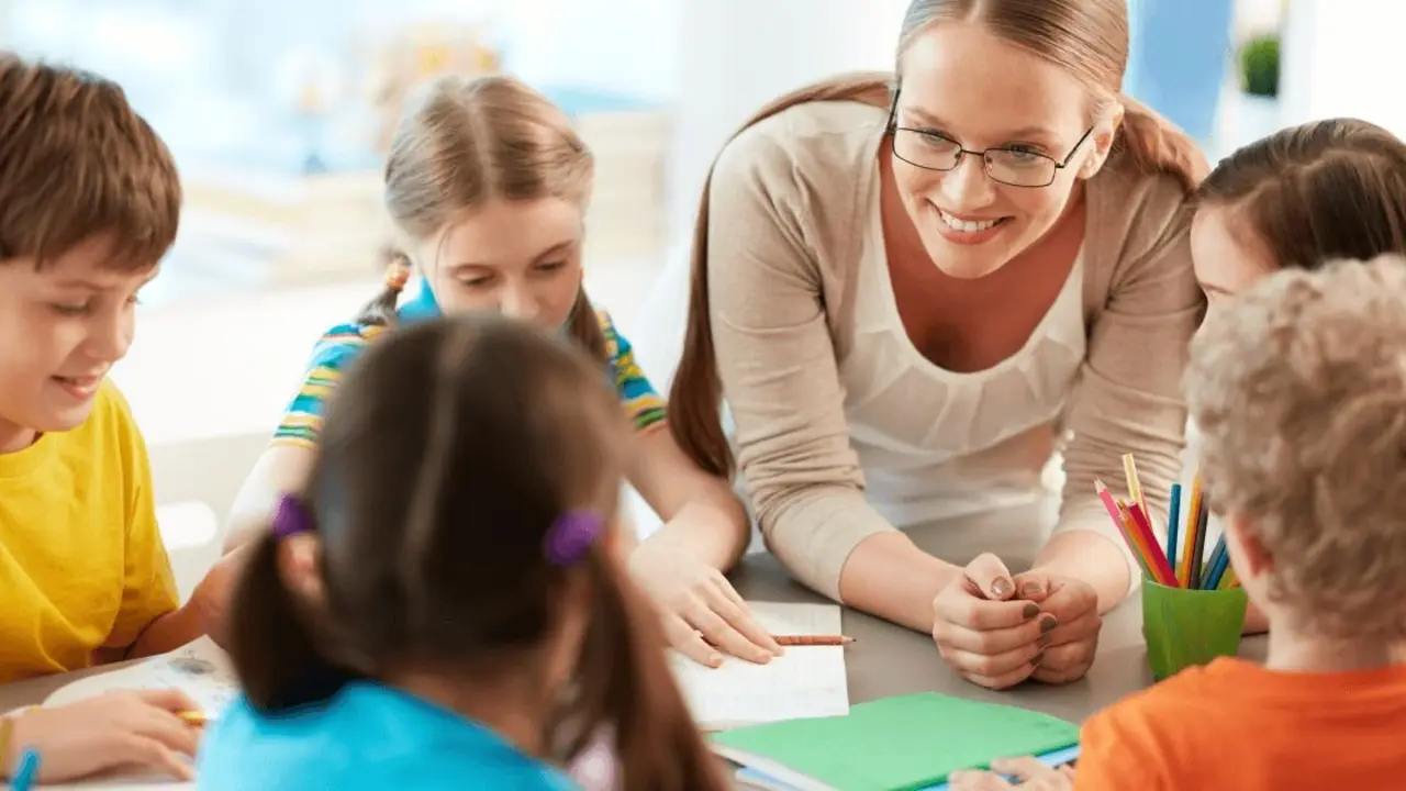 Un grupo de niños junto a una profesora en un aula.