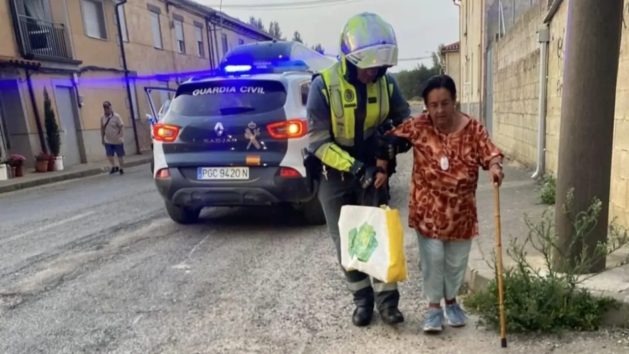Un agente de la Guardia Civil ayuda a una señora a ser evacuada por el incendio. Foto: Guarda Civil