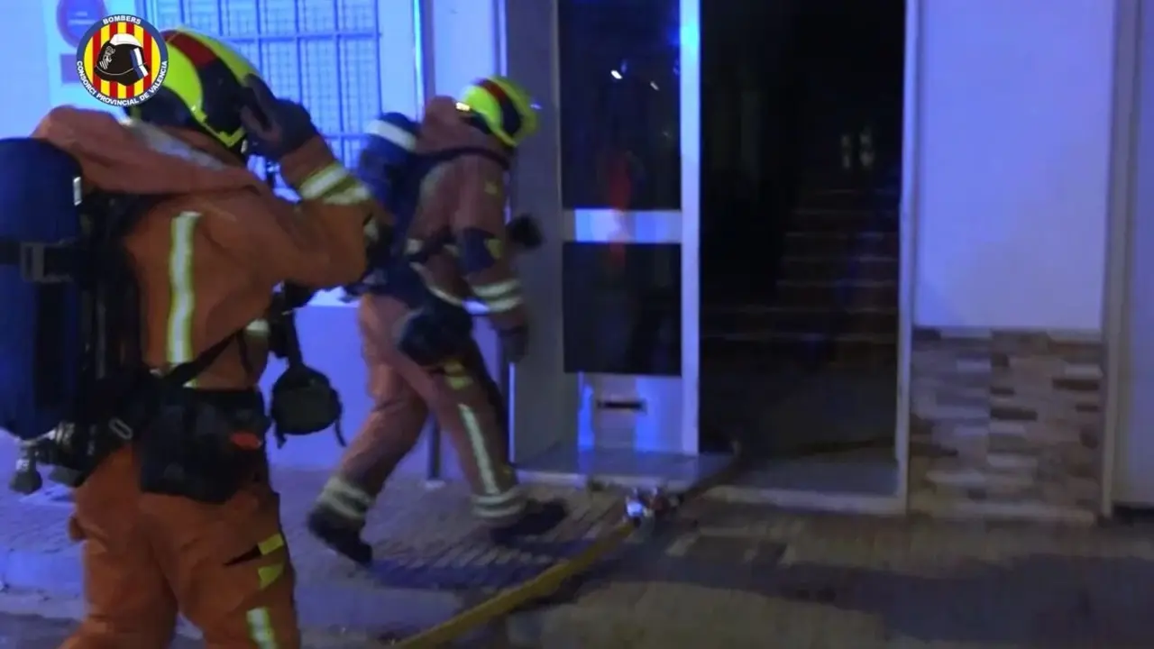 Bomberos entrando al edificio afectado.