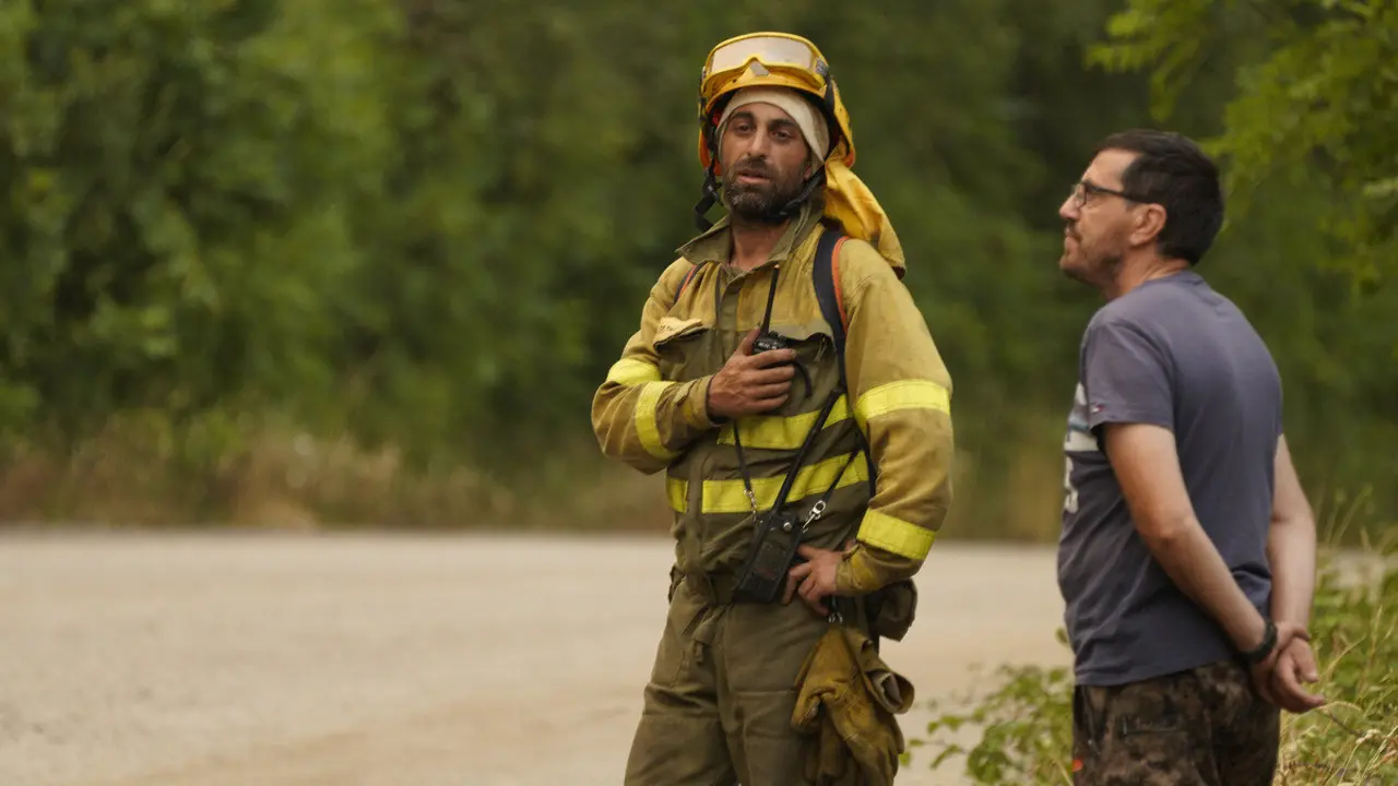 Un brigadista junto a un vecino durante un incendio en una imagen de archivo. Foto: César