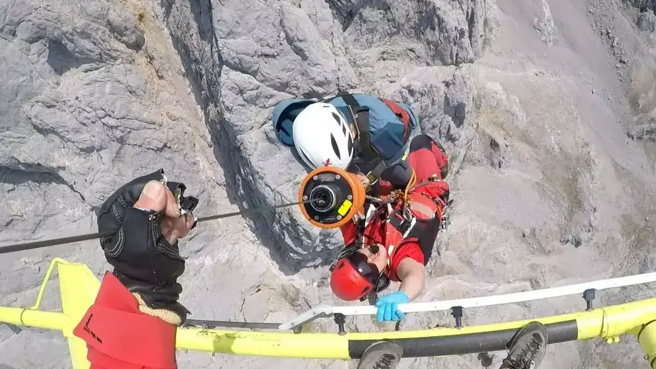Los rescatadores, durante el izado del herido.