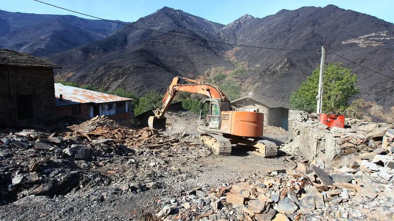 Trabajos de derribo y desescombro de las casas afectadas por el incendio en la localidad de Lusio.