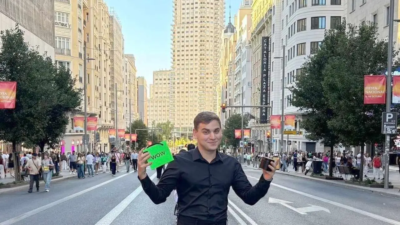 El leonés Rodrigo Villar con una vela de su marca "ARDAD" en su mano izquierda y con un bolsa de WOW Concept en la derecha en la Gran Vía de Madrid.