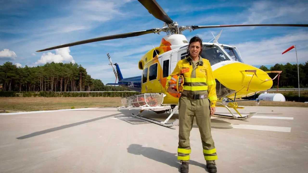 Sara, bombero forestal, junto al helicóptero en el que se desplaza.