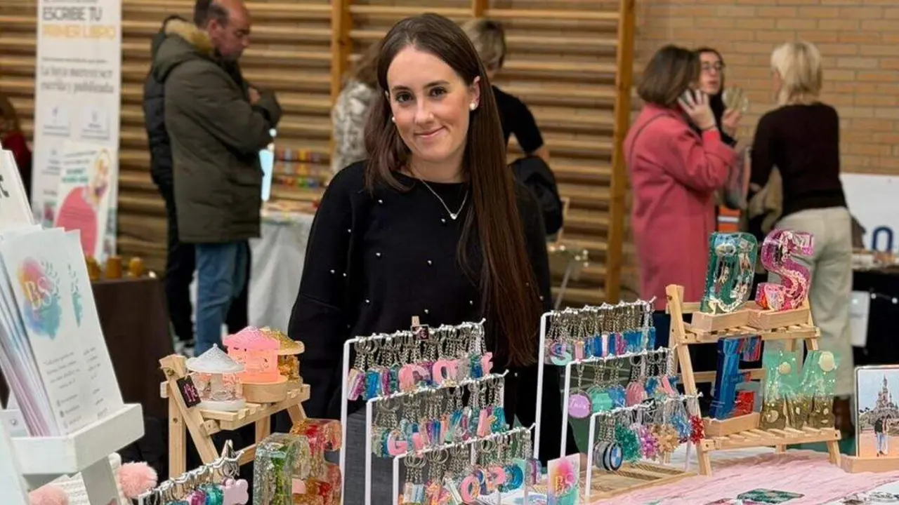 La leonesa Sara &Aacute;lvarez en la feria de mujeres emprendedoras de Nava al frente de su puesto "ResinabySara".