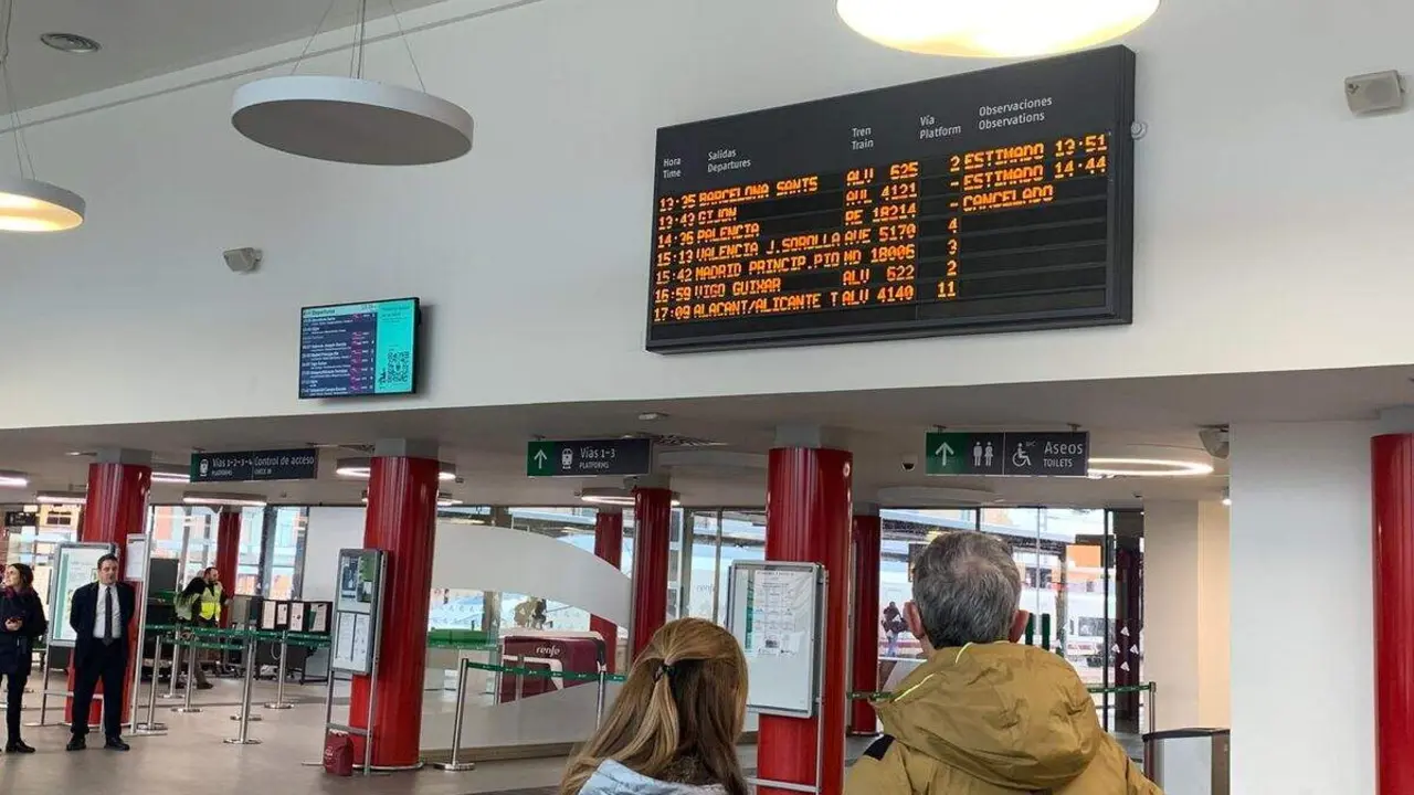 Usuarios del tren observan la pantalla con retrasos y cancelaciones de la Estaci&oacute;n de Le&oacute;n. Foto: A. Laliena