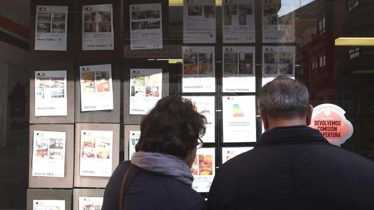 Una pareja mira los anuncios de una inmobiliaria en Valladolid