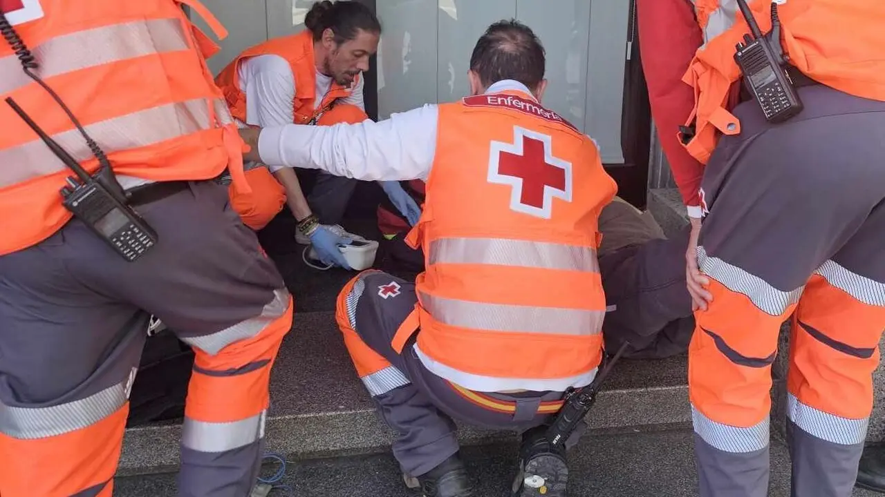 Efectivos de Cruz Roja durante la atenci&oacute;n a uno de los asistentes al acto procesional.