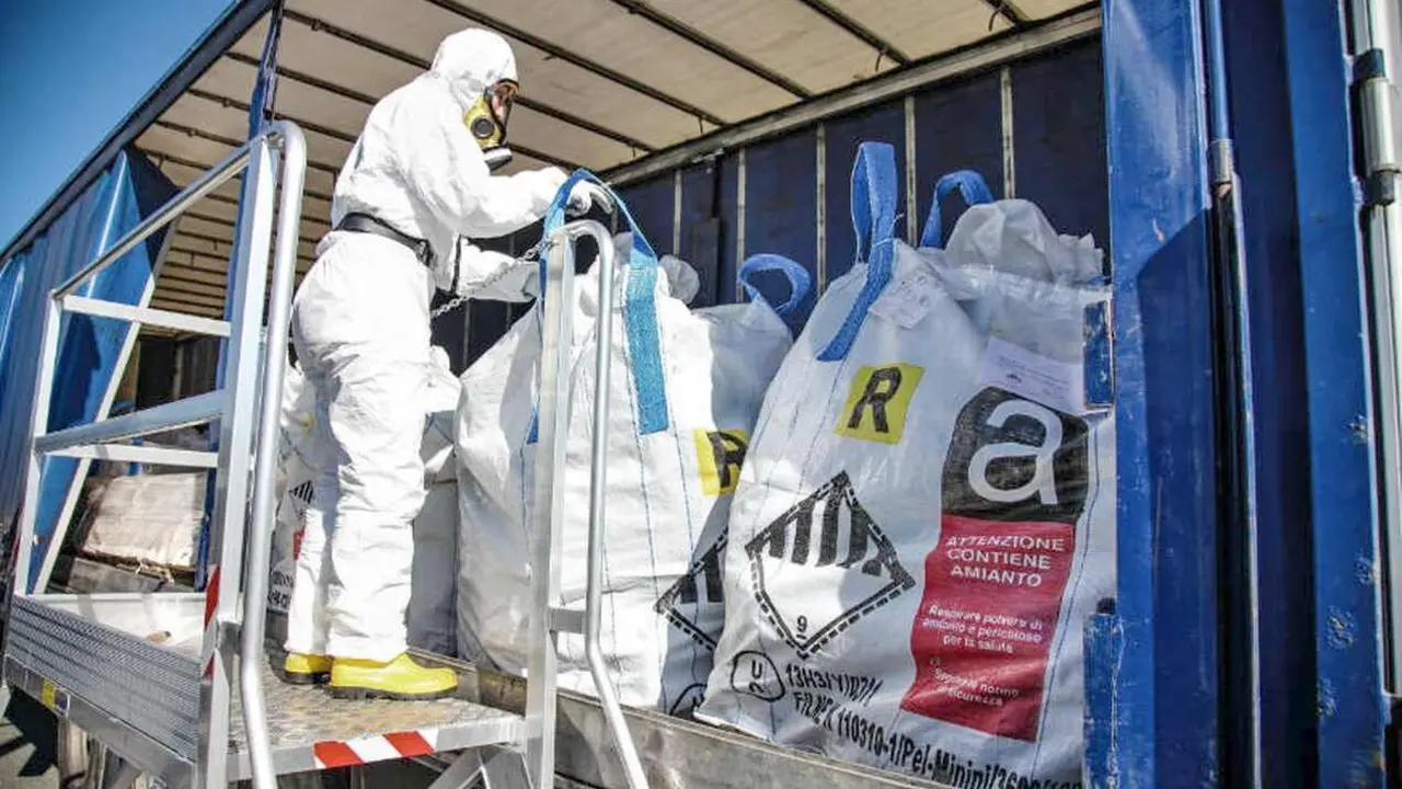 Obreros, con equipos especializados, proceden al movimiento de residuos con amianto.