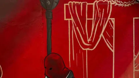 Cofrades, hermanos y devotos se unen en la crítica hacia el mural encargado por la cofradía en el cruce de la cuesta de las Carbajalas con la vieja calle Corta. Imágenes del artista @Dardobola_8, quien en el desarrollo del mural ha seguido el criterio de la cofradía según ha relatado él mismo.